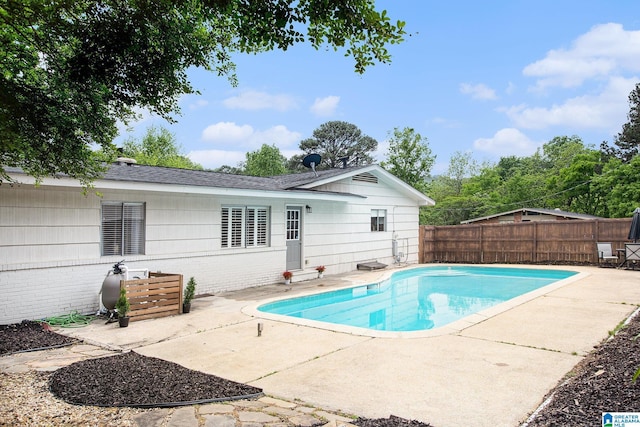 view of swimming pool featuring a fenced in pool, a fenced backyard, and a patio area