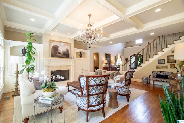 living area with arched walkways, coffered ceiling, wood finished floors, beamed ceiling, and stairway
