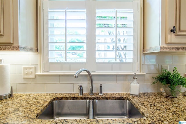kitchen with a sink, decorative backsplash, and plenty of natural light