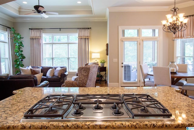kitchen with stainless steel gas cooktop, healthy amount of natural light, a chandelier, a ceiling fan, and ornamental molding