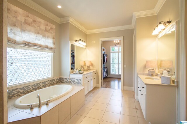 full bath with vanity, a walk in closet, a garden tub, ornamental molding, and tile patterned flooring