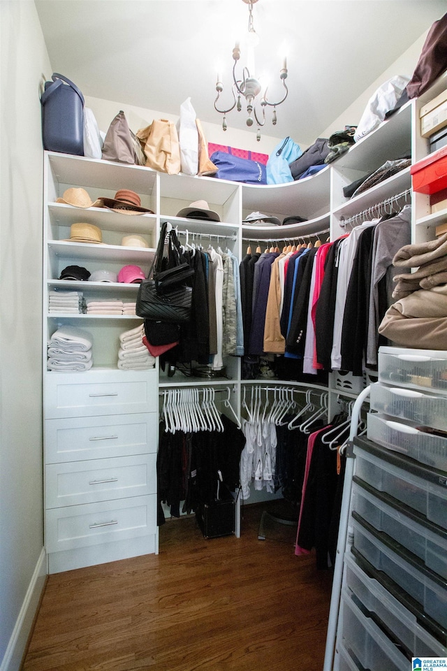 spacious closet with wood finished floors and a chandelier