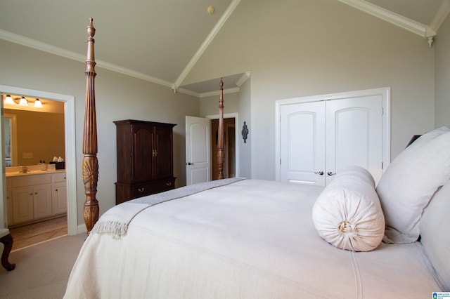 carpeted bedroom with ornamental molding, high vaulted ceiling, a closet, ensuite bath, and a sink