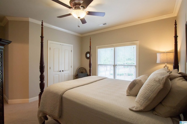 carpeted bedroom featuring baseboards, a closet, a ceiling fan, and ornamental molding