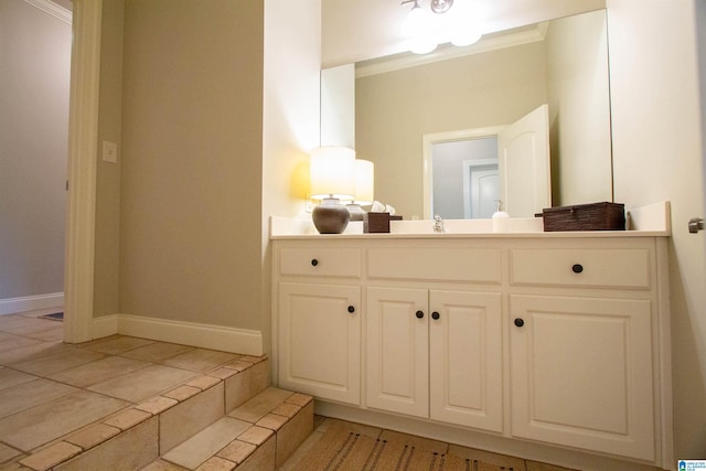 bathroom with baseboards, vanity, tile patterned flooring, and ornamental molding