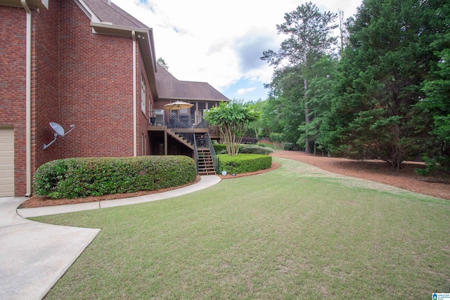 view of green lawn with stairway, a wooden deck, concrete driveway, and a garage