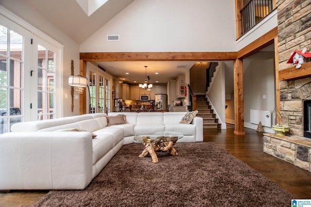 living room featuring visible vents, high vaulted ceiling, a chandelier, stairs, and dark wood-type flooring