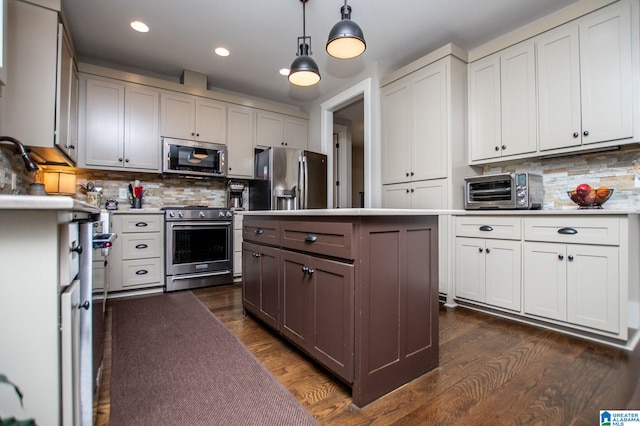 kitchen with a toaster, dark wood-type flooring, light countertops, backsplash, and stainless steel appliances