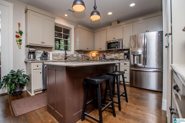kitchen featuring visible vents, dark wood-style flooring, appliances with stainless steel finishes, and backsplash