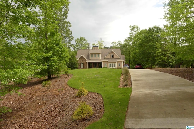 view of front facade featuring a chimney and a front lawn