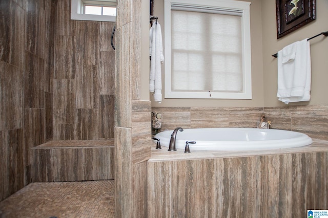 bathroom with a tile shower and a garden tub