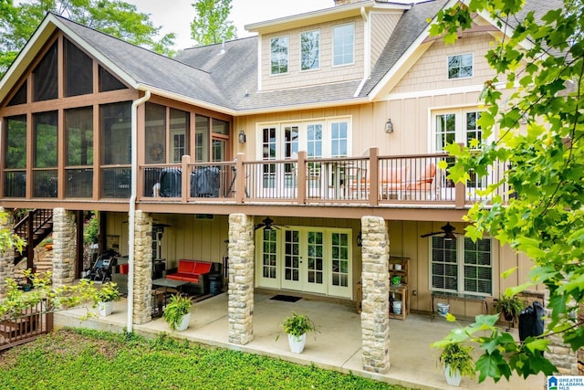 rear view of house with ceiling fan, a patio, french doors, a sunroom, and a shingled roof