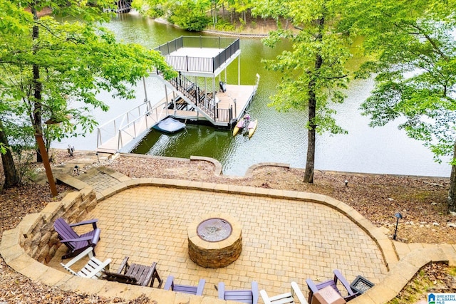 exterior space featuring a patio, a water view, and an outdoor fire pit
