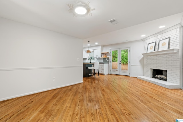 living area with light wood finished floors, visible vents, a fireplace, and recessed lighting