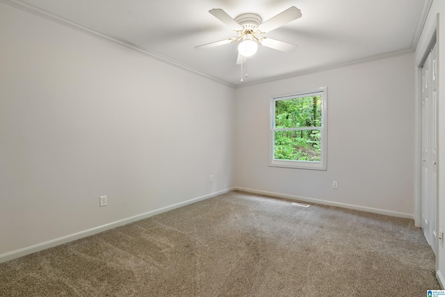 interior space featuring visible vents, a ceiling fan, carpet floors, crown molding, and baseboards
