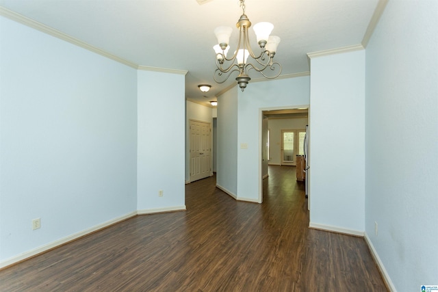 unfurnished room with ornamental molding, an inviting chandelier, and dark wood-style flooring