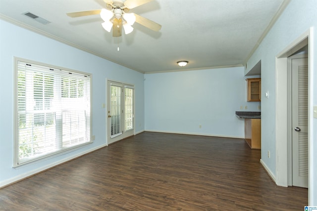 unfurnished living room featuring crown molding, a ceiling fan, visible vents, and dark wood-style flooring
