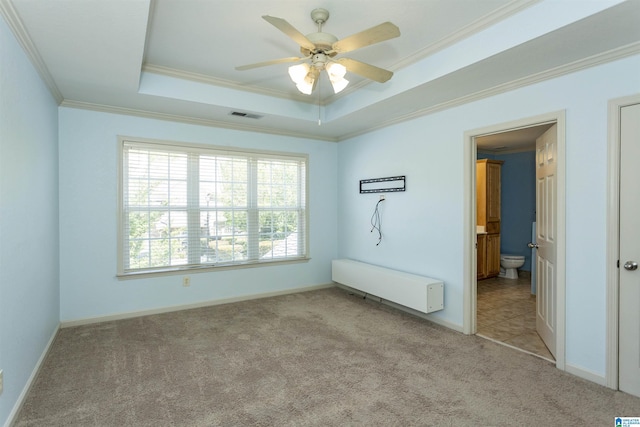 spare room with light colored carpet, visible vents, a tray ceiling, radiator, and ornamental molding