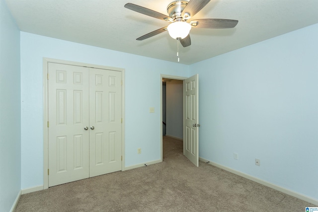 unfurnished bedroom with ceiling fan, baseboards, carpet flooring, and a closet