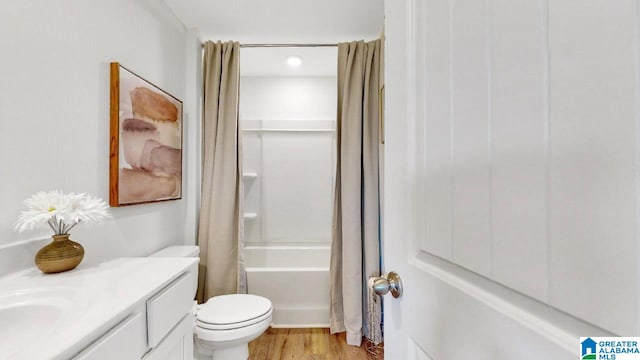 full bath featuring toilet, shower / tub combo with curtain, vanity, and wood finished floors