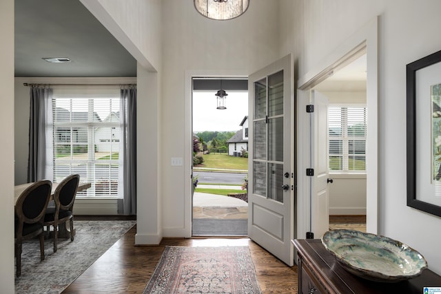 doorway to outside with a wealth of natural light, wood finished floors, and baseboards