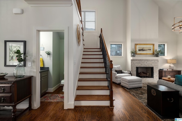stairs with wood finished floors and a fireplace