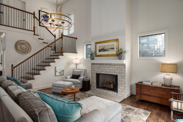 living room featuring a chandelier, baseboards, stairs, and a towering ceiling