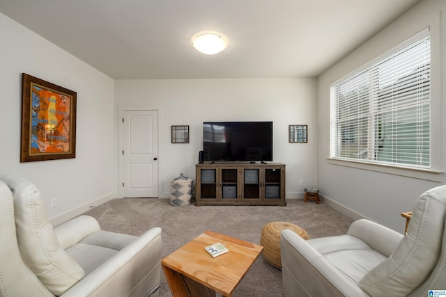 carpeted living area featuring baseboards