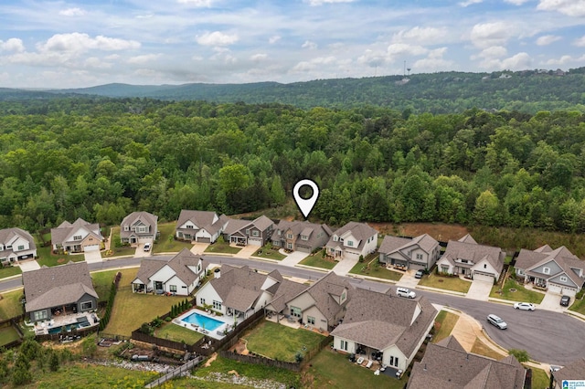 drone / aerial view with a wooded view and a residential view