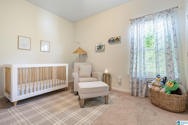 bedroom with a nursery area, baseboards, and carpet
