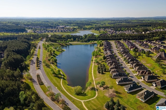 drone / aerial view with a forest view, a water view, and a residential view