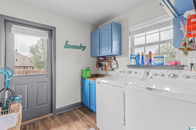 clothes washing area with washing machine and clothes dryer, baseboards, dark wood-style floors, and cabinet space