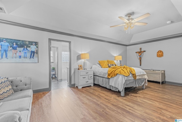 bedroom featuring vaulted ceiling, a ceiling fan, connected bathroom, light wood-style flooring, and baseboards