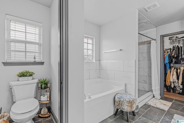 full bathroom with visible vents, a garden tub, a stall shower, and toilet
