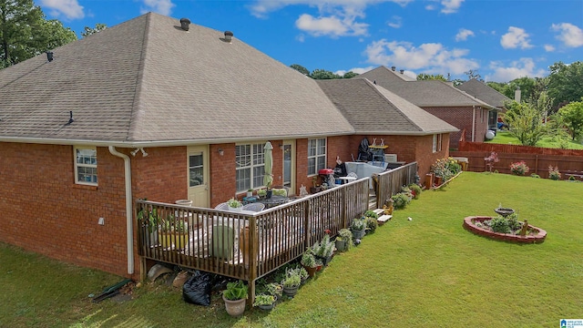 rear view of house with brick siding, a lawn, a shingled roof, and a fenced backyard