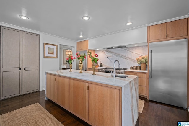 kitchen with a sink, dark wood-style flooring, stainless steel built in fridge, an island with sink, and stainless steel refrigerator