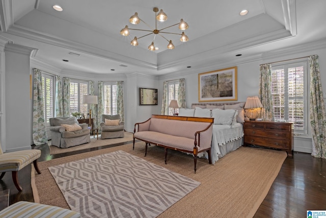 bedroom featuring an inviting chandelier, wood finished floors, a raised ceiling, and crown molding