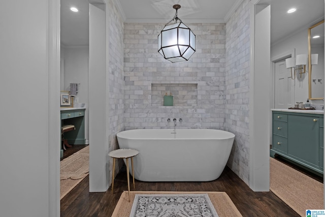 full bath featuring crown molding, vanity, a freestanding tub, and wood finished floors