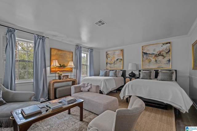 bedroom featuring visible vents, multiple windows, and wood finished floors