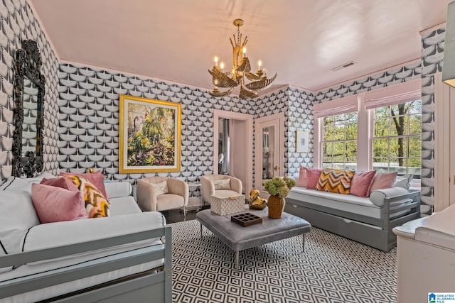 living room featuring visible vents, an inviting chandelier, and wallpapered walls