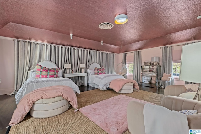 bedroom with visible vents, wood finished floors, and multiple windows