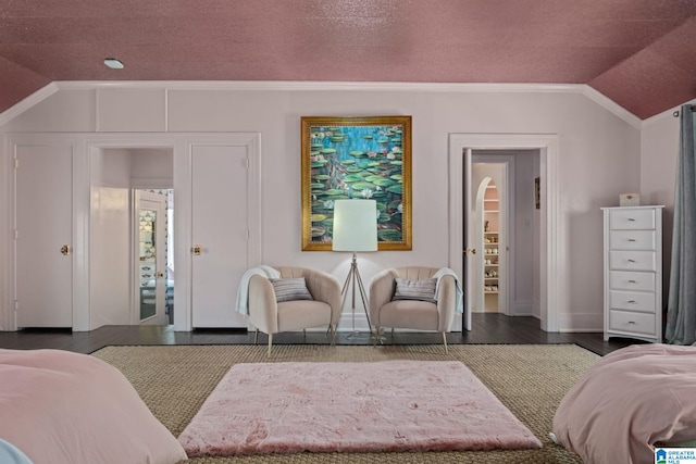 bedroom featuring ornamental molding, vaulted ceiling, wood finished floors, and baseboards