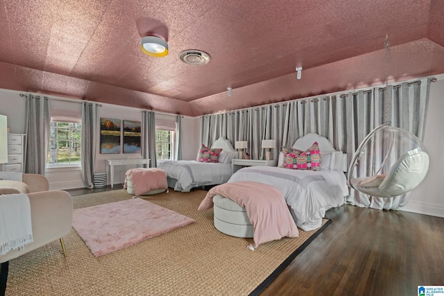 bedroom with wood finished floors, visible vents, and baseboards