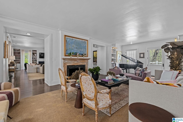 living room with a fireplace, dark wood-style flooring, a wealth of natural light, and ornamental molding