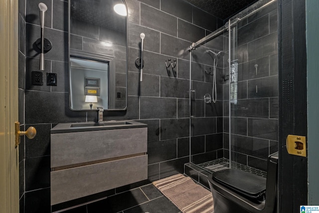 bathroom featuring tile patterned floors, tile walls, tiled shower, and vanity