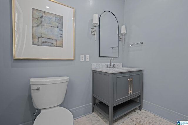 bathroom with vanity, toilet, and baseboards
