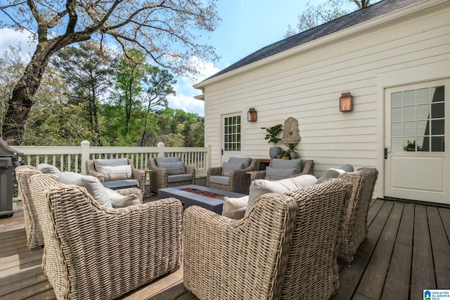 deck with an outdoor living space with a fire pit