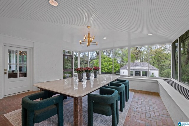 sunroom / solarium featuring a notable chandelier