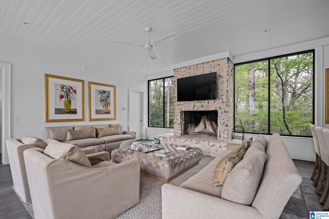 living area featuring wooden ceiling, ceiling fan, and a fireplace