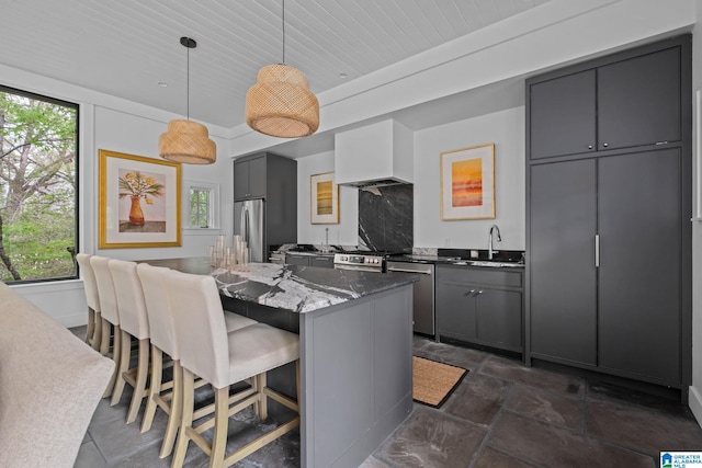 kitchen featuring stone tile floors, gray cabinetry, stainless steel appliances, and wooden ceiling
